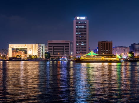 Dubai, UAE - 30 March 2023: View across the Creek towards Deira as tour boats pass along the water