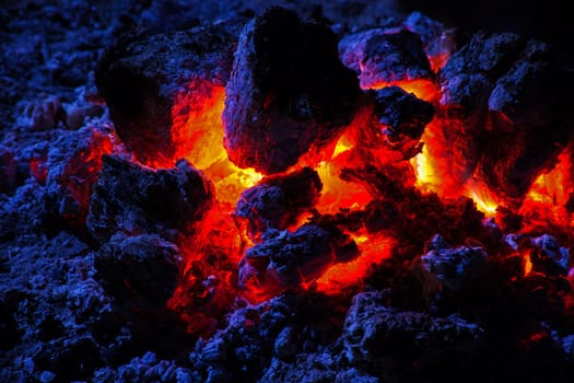 The red hot glowing embers after the flames of a campfire burnt out