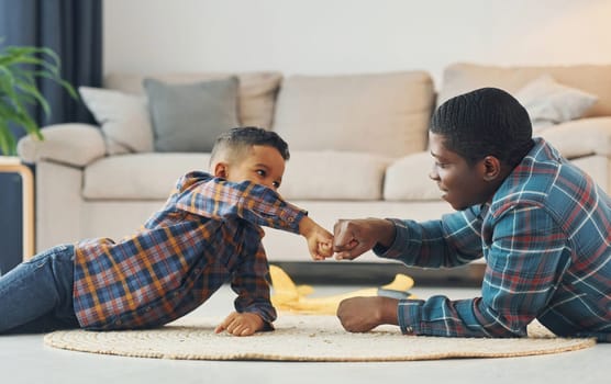 Having fun. African american father with his young son at home.