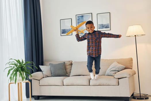 Having fun. Cheerful young boy is at home alone.
