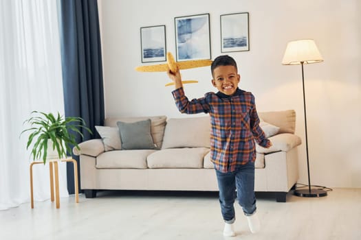 Having fun. Cheerful young boy is at home alone.