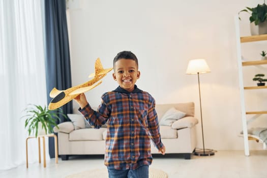 Having fun. Cheerful young boy is at home alone.
