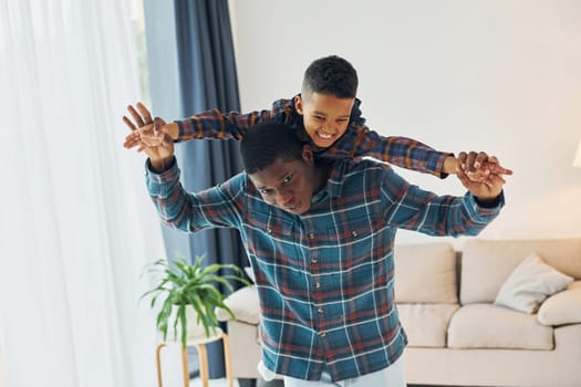 Having fun. African american father with his young son at home.
