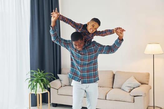 Having fun. African american father with his young son at home.