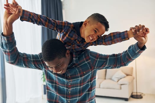 Having fun. African american father with his young son at home.