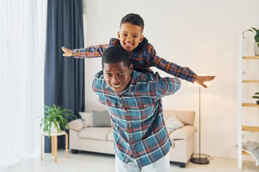 Having fun. African american father with his young son at home.