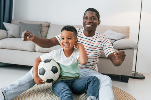 Entertainment for people. African american father with his young son at home.