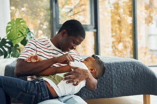 Playing and having fun. African american father with his young son at home.