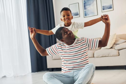 African american father with his young son at home.