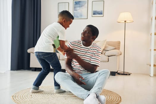 African american father with his young son at home.