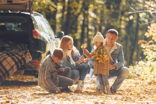 Beautiful leaves. Happy family is in the park at autumn time together.