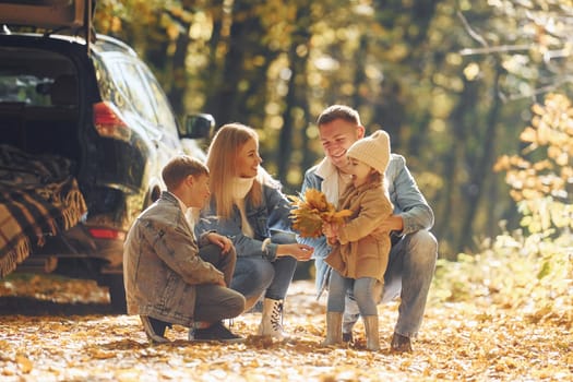 Beautiful leaves. Happy family is in the park at autumn time together.