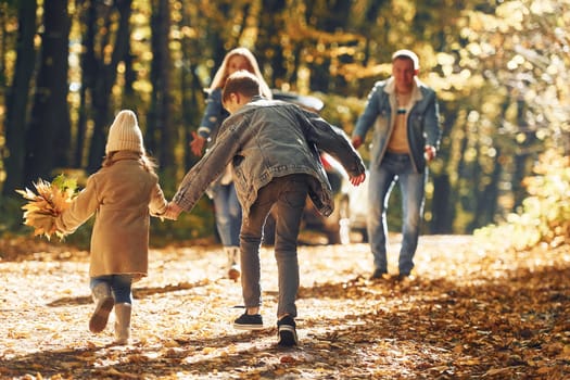 Sister with brother walking. Happy family is in the park at autumn time together.
