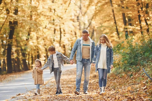 Cheerful people. Happy family is in the park at autumn time together.