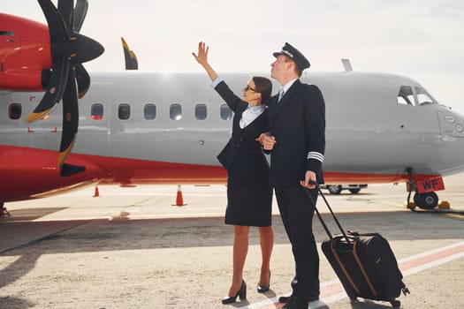 Pilot and stewardess. Crew of airport and plane workers in formal clothes standing outdoors together.