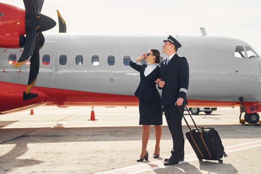 Pilot and stewardess. Crew of airport and plane workers in formal clothes standing outdoors together.