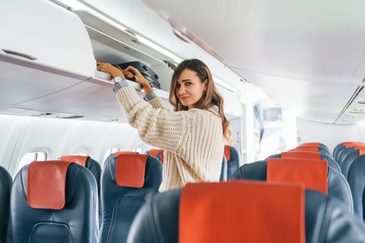 Conception of vaccation. Young female passanger in casual clothes is in the plane.