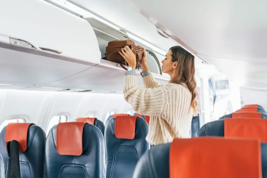 Conception of vaccation. Young female passanger in casual clothes is in the plane.