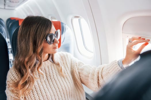 Conception of vaccation. Young female passanger in casual clothes is in the plane.