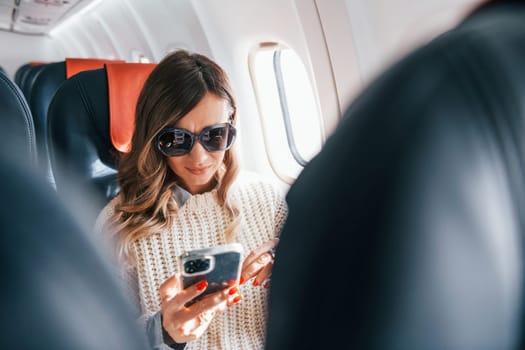 Conception of vaccation. Young female passanger in casual clothes is in the plane.