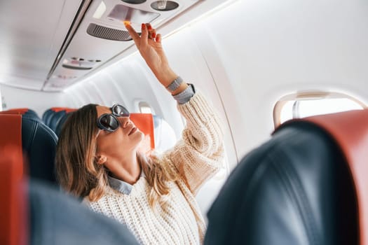 Young tourist. Female passanger in casual clothes is in the plane.