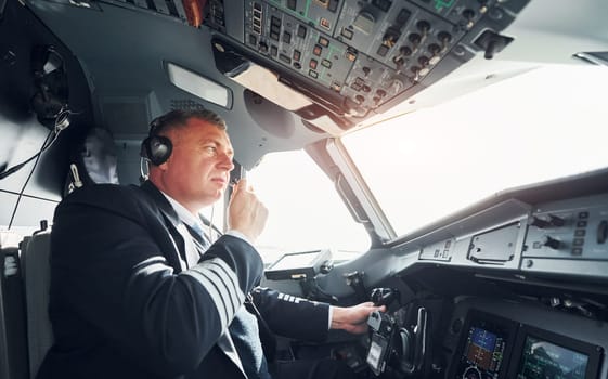 Side view. A professional pilot is in the cockpit. Conception of work.