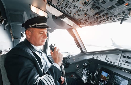 A professional pilot is in the cockpit. Conception of work.