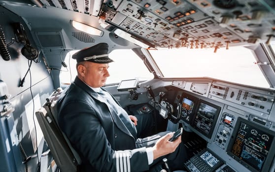 Side view. A professional pilot is in the cockpit. Conception of work.