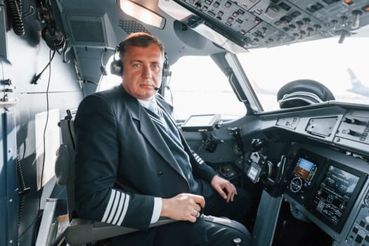 Side view. A professional pilot is in the cockpit. Conception of work.