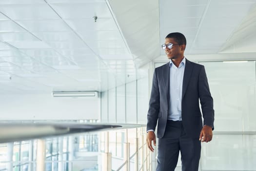 Young african american businessman in black suit is indoors.