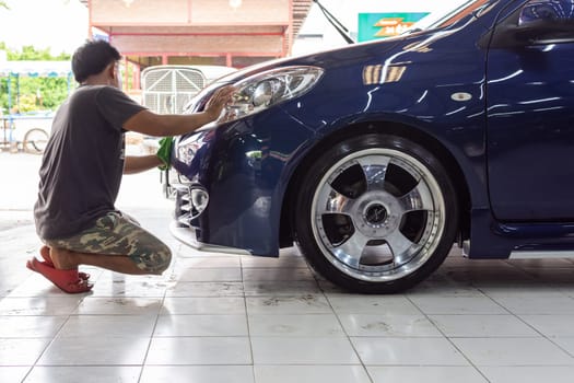 Bangkok, Thailand - October 2, 2016 : Unidentified car care staff cleaning (clean, wash, polish, wax and glass coating) the car (Car detailing) at car care shop in Bangkok Thailand