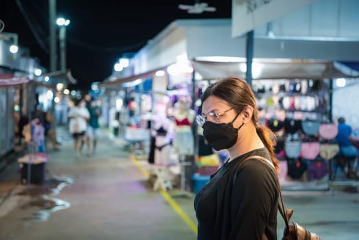 Beautiful asian woman (LGBTQ) natural makeup wear fashion yellow leather clothes with glasses posing with food or drink at thai street food, market or restaurant outdoor fashion style