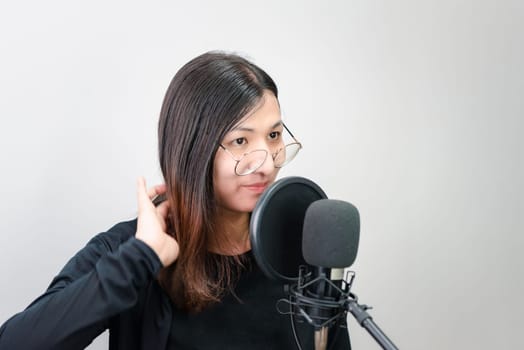 Beautiful asian woman (LGBTQ) is a singer. She enjoying sing a song or karaoke in music studio with microphone condenser and headphones for fun or voice creative