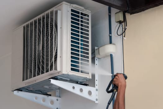 Worker to cleaning coil cooler of air conditioner by water for clean a dust on the wall in customer home when maintenance service