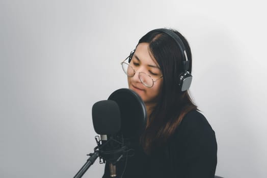 Beautiful asian woman (LGBTQ) is a singer. She enjoying sing a song or karaoke in music studio with microphone condenser and headphones for fun or voice creative