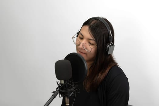 Beautiful asian woman (LGBTQ) is a singer. She enjoying sing a song or karaoke in music studio with microphone condenser and headphones for fun or voice creative