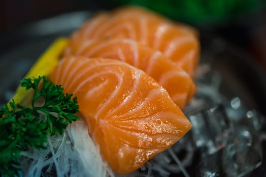 Japanese food delicacy consisting sashimi salmon of very fresh raw salmon fish sliced into thin pieces serving with radish sliced in japan restaurant