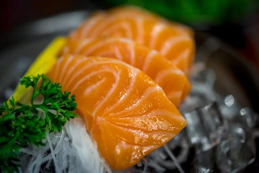 Japanese food delicacy consisting sashimi salmon of very fresh raw salmon fish sliced into thin pieces serving with radish sliced in japan restaurant