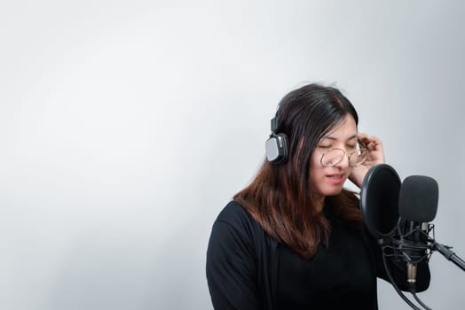 Beautiful asian woman (LGBTQ) is a singer. She enjoying sing a song or karaoke in music studio with microphone condenser and headphones for fun or voice creative