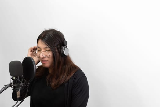 Beautiful asian woman (LGBTQ) is a singer. She enjoying sing a song or karaoke in music studio with microphone condenser and headphones for fun or voice creative