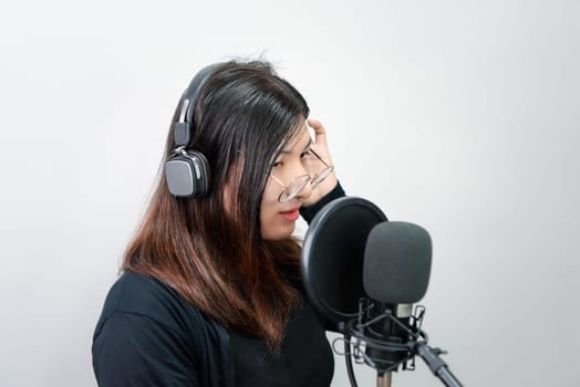 Beautiful asian woman (LGBTQ) is a singer. She enjoying sing a song or karaoke in music studio with microphone condenser and headphones for fun or voice creative