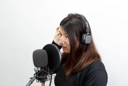 Beautiful asian woman (LGBTQ) is a singer. She enjoying sing a song or karaoke in music studio with microphone condenser and headphones for fun or voice creative