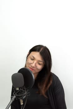 Beautiful asian woman (LGBTQ) is a singer. She enjoying sing a song or karaoke in music studio with microphone condenser and headphones for fun or voice creative