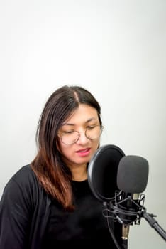 Beautiful asian woman (LGBTQ) is a singer. She enjoying sing a song or karaoke in music studio with microphone condenser and headphones for fun or voice creative