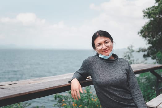 Beautiful asian woman (LGBTQ) natural makeup wear fashion relax clothes posing at sea viewpoint with happy and fun emotion in concept travel, vacation, leisure in life