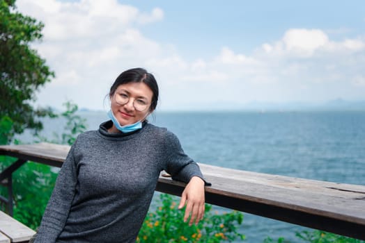 Beautiful asian woman (LGBTQ) natural makeup wear fashion relax clothes posing at sea viewpoint with happy and fun emotion in concept travel, vacation, leisure in life