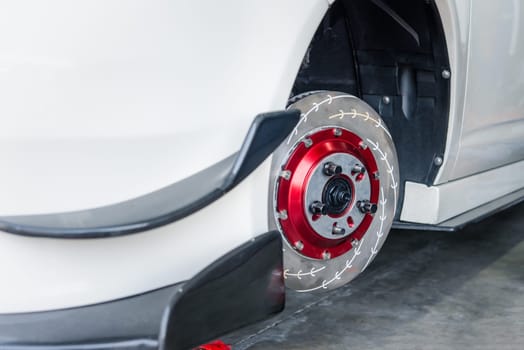 Car mechanic or serviceman disassembly and checking a disc brake and asbestos brake pads for fix and repair problem at car garage or repair shop