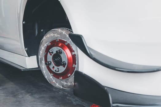 Car mechanic or serviceman disassembly and checking a disc brake and asbestos brake pads for fix and repair problem at car garage or repair shop