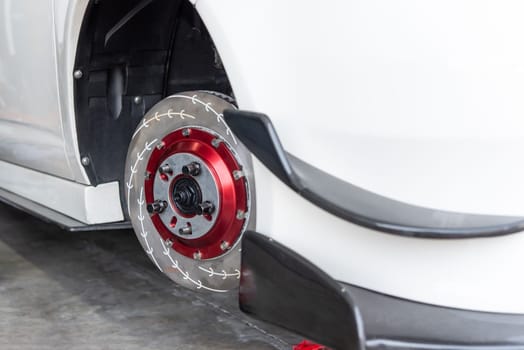 Car mechanic or serviceman disassembly and checking a disc brake and asbestos brake pads for fix and repair problem at car garage or repair shop