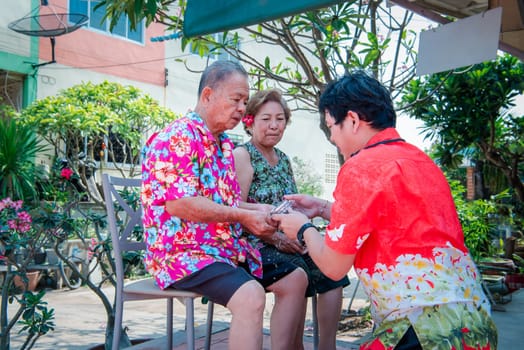 Asian people bathe respectation to elderly parents by water with jasmine, rose flower and aromatherapy in bowl in Songkran Festival (Thai New Year)